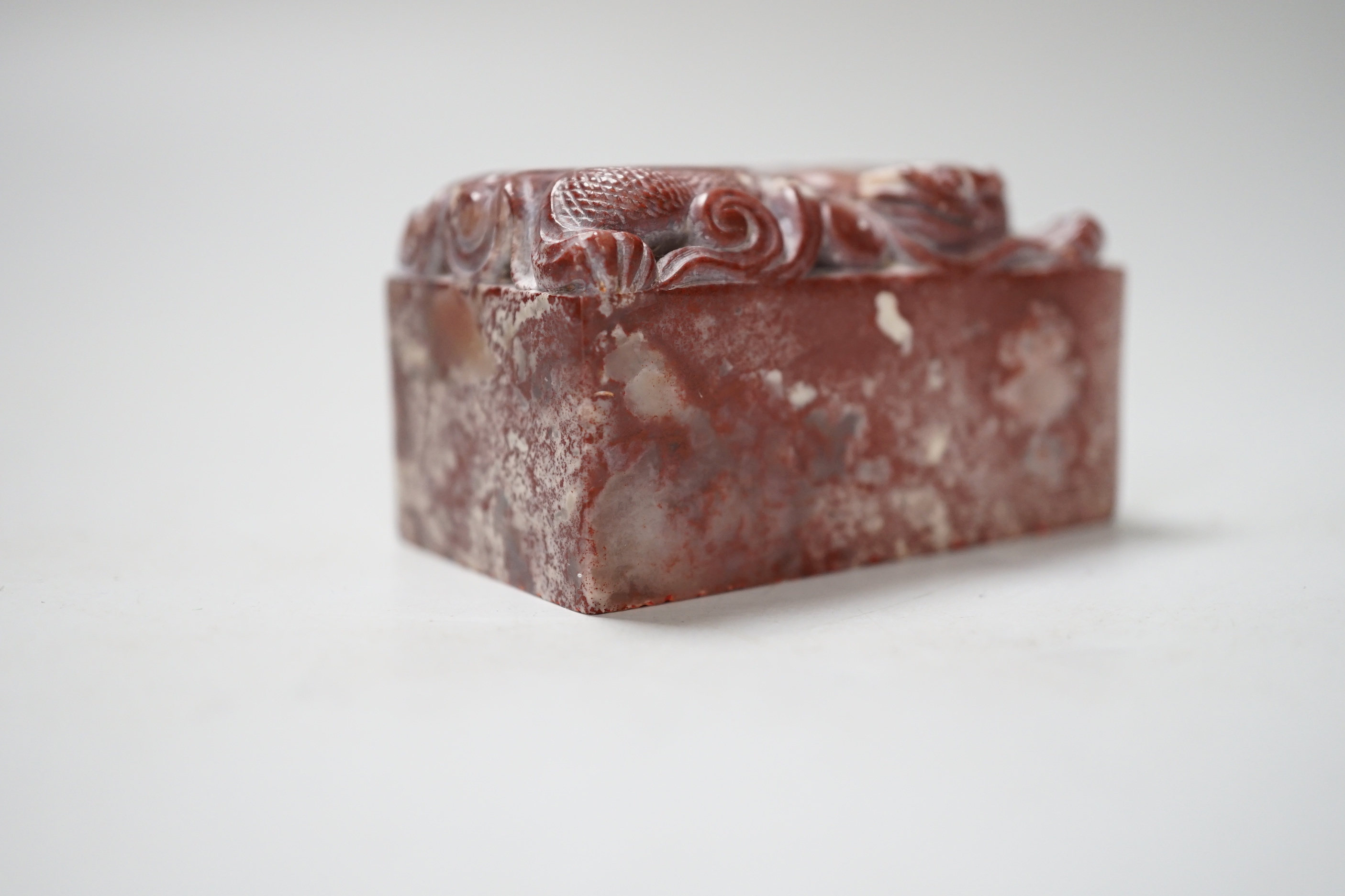 A Chinese chicken’s blood inscribed soapstone seal, carved with a dragon, 6cm